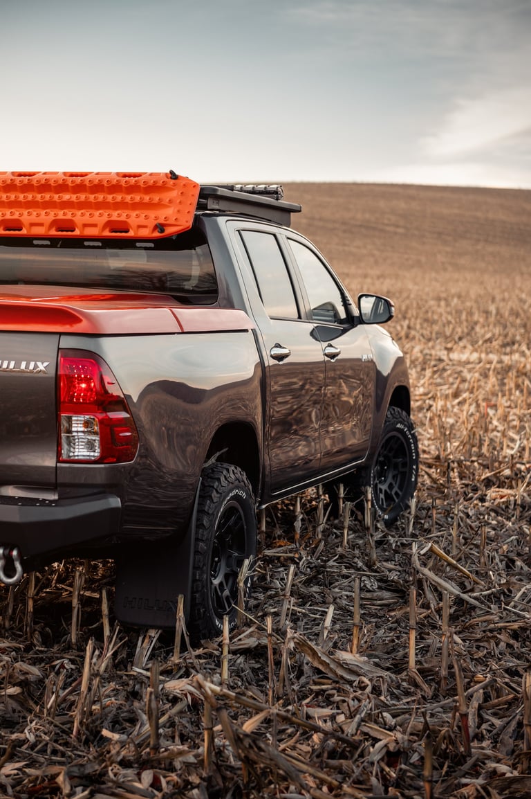 Rear side view of pickup truck with bed cover in harvested corn field