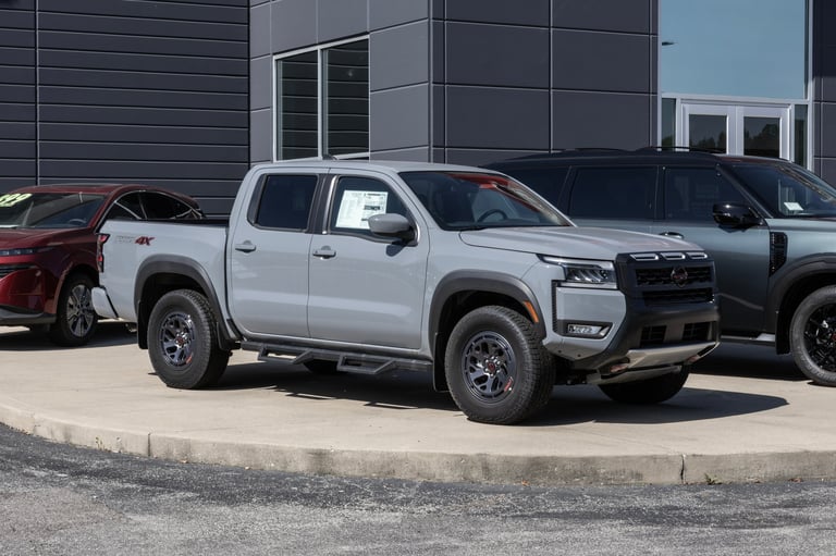 Nissan Frontier PRO-4X Crew Cab 4X4 pickup display at a dealership with 3.8L V6 engine