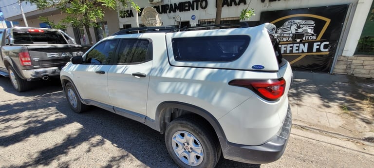 White SUV parked on street with other vehicles and storefronts in background