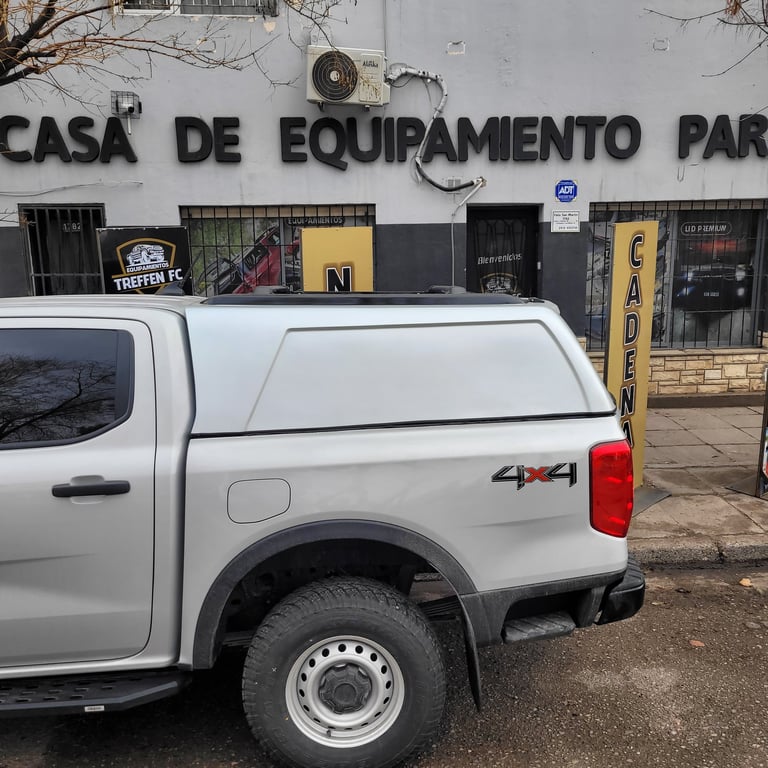 White pickup truck parked in front of a Portuguese equipment store