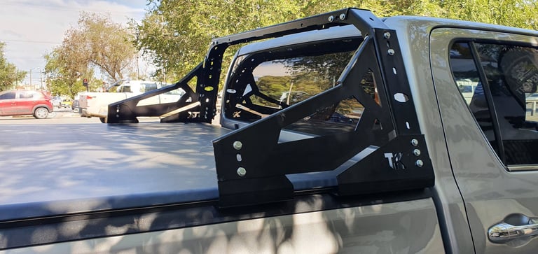 Pickup truck with open driver-side door showing black interior, parked on sunny residential street with trees