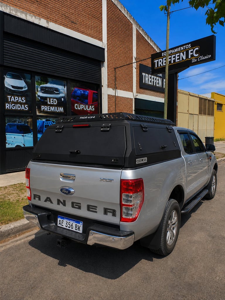 Silver Ford Ranger pickup truck with black canopy parked in front of Treffen FC storefront with signage