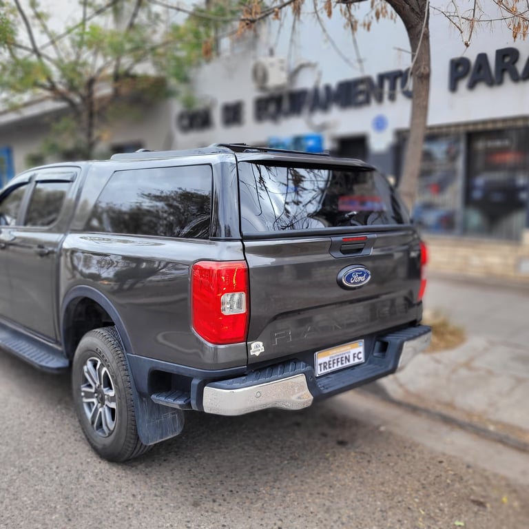 Black Ford pickup truck parked on street with blue lights on roof