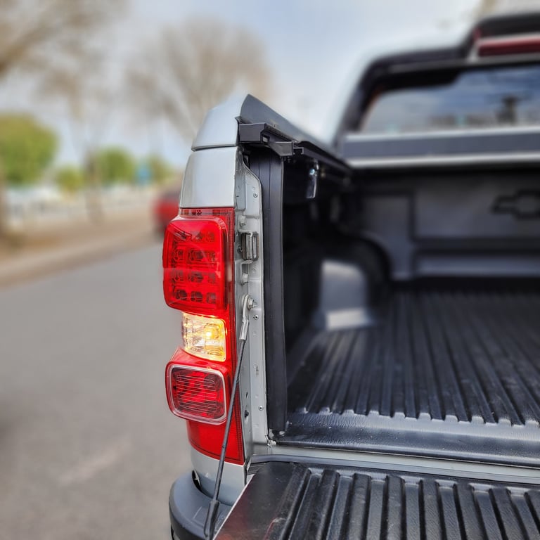 Close-up of a trucks red tail light mounted on the side of the cargo bed, showing multiple LED light segments