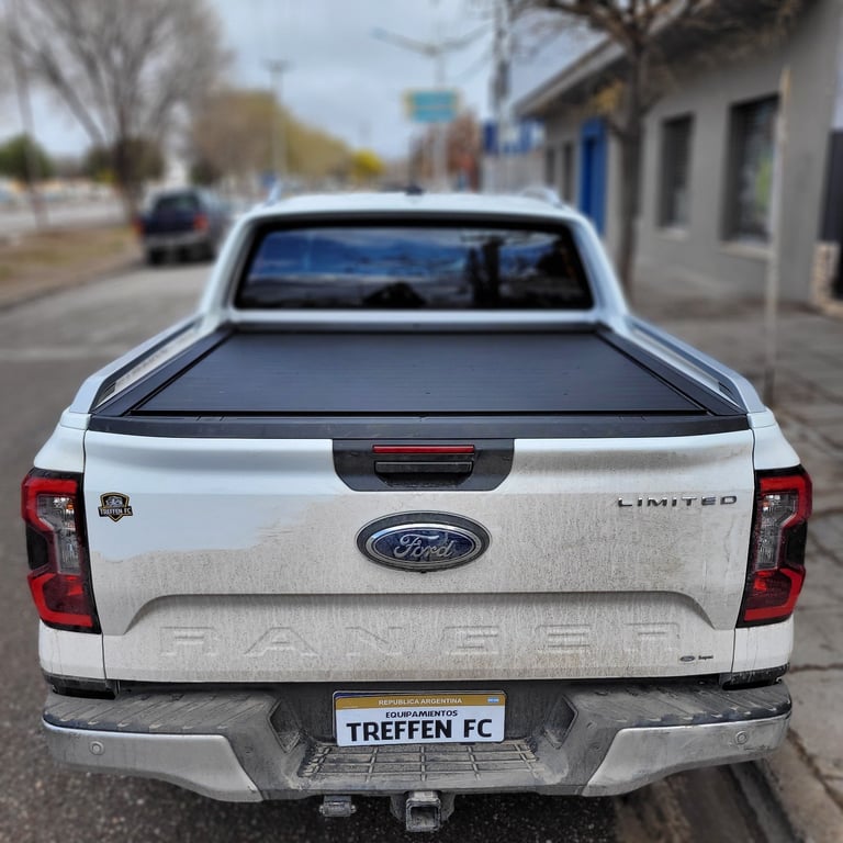 White Ford pickup truck with tonneau cover parked on street, rear view showing license plate