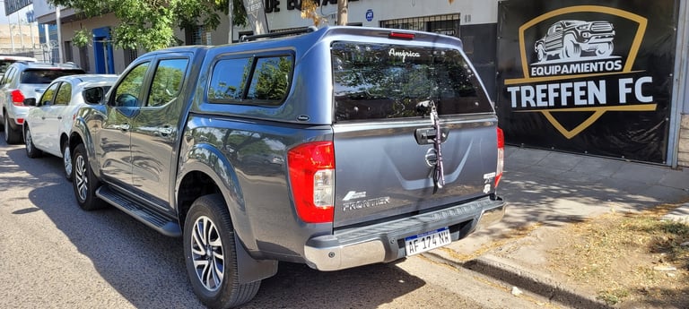 Gray pickup truck parked in front of Treffen FC building with other vehicles visible in the background