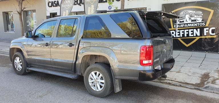 Silver pickup truck parked on street with Reffen FC logo visible in background