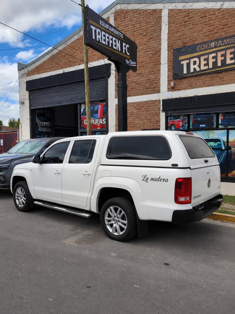 White pickup truck parked in front of Treffen FC brick building with signage