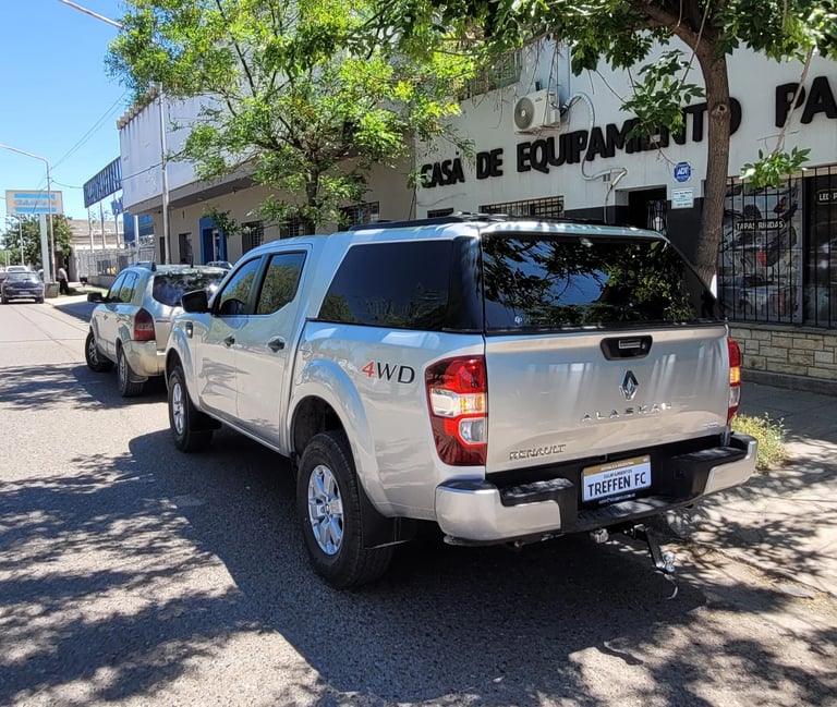 White pickup truck parked on street with industrial building in background