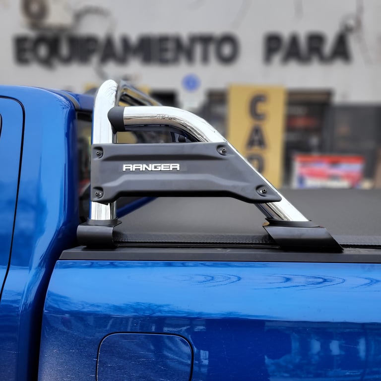 Blue Ford Ranger pickup truck with a black roll bar and metal roof rack mounted on the truck bed