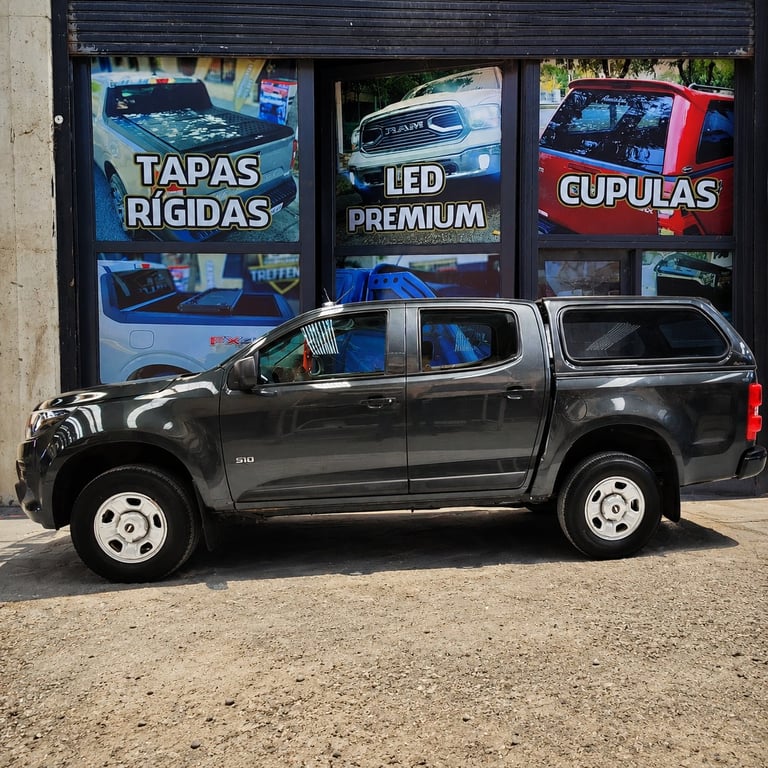 Black pickup truck parked in front of auto shop storefront with LED and car accessory signage
