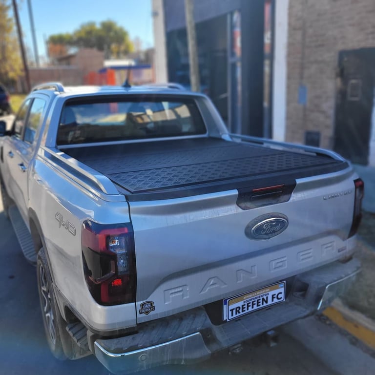 White Ford Ranger pickup truck with black tonneau cover in a parking lot