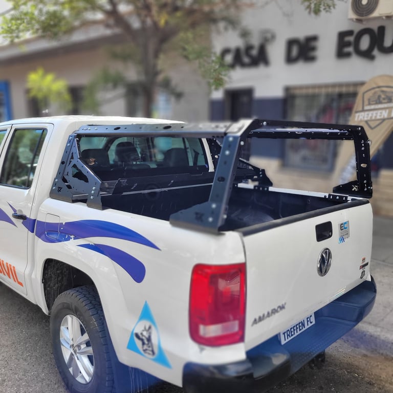 White Volkswagen pickup truck with blue and orange trim parked on a street with open truck bed and doors
